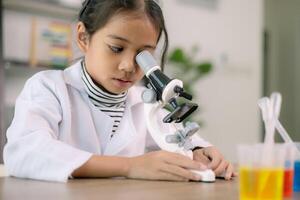 asiático niño niña aprendizaje Ciencias química con prueba tubo haciendo experimentar a colegio laboratorio. educación, ciencia, química, y para niños conceptos. temprano desarrollo de niños. foto