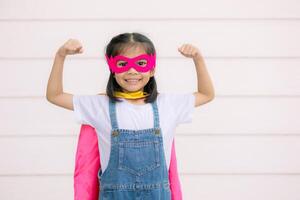 A funny little girl wearing a Superhero costume. Superhero concept. photo