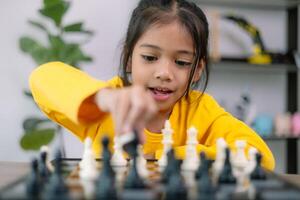 A young girl is playing a game of chess photo