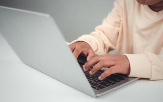 Young businessman hand typing on laptop computer while working in white modern office room for business or technology background, Contact and communication in the organization. photo