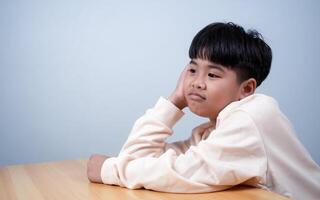 The boy was sitting and thinking about various stories, analyzing and sorting things out. photo