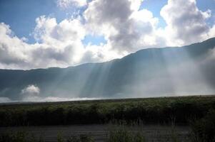 Photo of a valley under a misty mountain