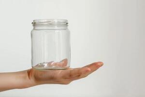 AI generated Hand Holding Empty Glass Jar Isolated on White Background photo