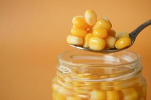 spoon pick Sweet corns from a container photo