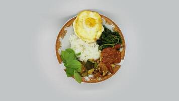 a plate of pecel lele or tempe penyet rotating on a plain background video