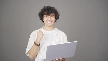 The young man is happy with what he sees on the laptop. video