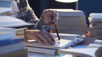 hombre leyendo libros y haciendo investigación a su escritorio. video