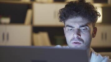 jovem homem é usando computador portátil dentro fechar-se. video