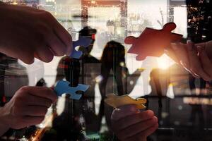 Businessmen working together to build a puzzle as teamwork, partnership and integration concept photo