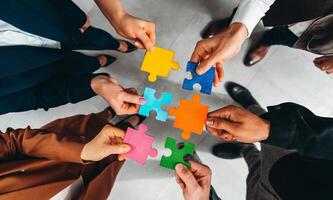Businessmen working together to build a puzzle as teamwork, partnership and integration concept photo
