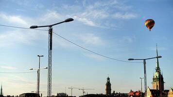 walking in the historic center of Stockholm. You can see the construction site cranes and a hot air balloon. photo