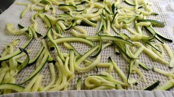 Zucchini cut into strips and placed on a cotton cloth to dry photo