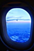 Digital painting style that represents the window of an airplane from which you can see a wing, the sky and the clouds photo