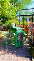 Digital painting style representing a small green table and a small greenhouse photo