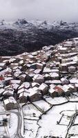 vertical vídeo Vila do pitoes das Júnias dentro Portugal coberto com neve depois de tempestade video