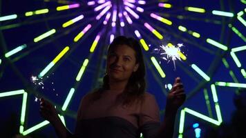 A beautiful happy girl is happy with a holiday with fireworks in her hands. slow motion. video