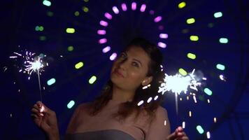 un attraente contento ragazza è contento con un' vacanza con fuochi d'artificio nel sua mani. lento movimento. HD video