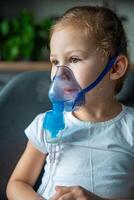 Cute little girl are sitting and holding a nebulizer mask leaning against the face, airway treatment concept photo