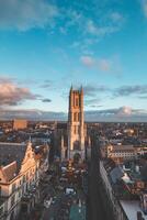 acecho el puesta de sol terminado Gante desde el histórico torre en el ciudad centro. romántico colores en el cielo. rojo ligero esclarecedor gante, flandes región, Bélgica foto