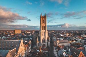 acecho el puesta de sol terminado Gante desde el histórico torre en el ciudad centro. romántico colores en el cielo. rojo ligero esclarecedor gante, flandes región, Bélgica foto