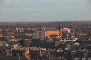 Watching the sunset over Ghent from the historic tower in the city centre. Romantic colours in the sky. Red light illuminating Ghent, Flanders region, Belgium photo