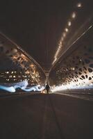 famoso puente llamado parqueburg en el norte de amberes un mujer iluminado por vigas de ligero en un agujereado hierro puente. Belga arquitectura foto