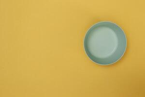 empty green plate on yellow background with copy space. Healthy eating, diet concept. Banner photo