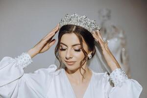 lujo Boda corona diadema en de la novia cabeza peinado.retrato. Mañana Boda preparación novia con corona cerca arriba foto