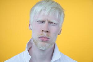 retrato de un albino hombre en estudio vestido camiseta aislado en un amarillo antecedentes. anormal desviaciones raro apariencia foto