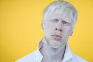 albinismo albino hombre en estudio vestido camiseta aislado en un amarillo antecedentes. anormal desviaciones raro apariencia foto