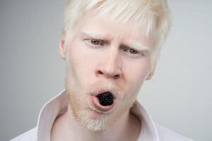 retrato de un albino hombre en estudio vestido camiseta aislado en un blanco antecedentes. anormal desviaciones raro apariencia foto