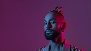 Neon light studio close-up portrait handsome black gay man looking camera. photo