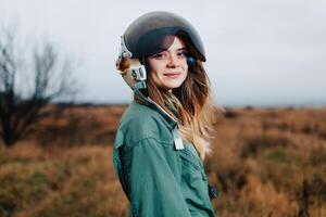 beautiful woman pilot of plane standing in the sunset field photo