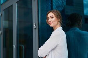 Businesswoman successful woman business person standing arms crossed outdoor corporate building exterior. Pensiv caucasian confidence professional business woman middle age photo