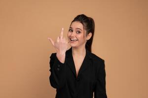 Business woman showing abuse gesture. Irritated smiling female in business suit showing middle finger, impolite rude gesture of disrespect, expressing hate and aggression in conflict photo