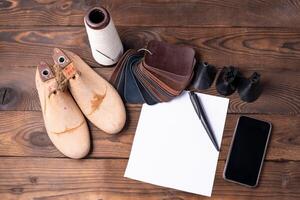 cuero muestras para Zapatos y de madera zapato último en oscuro de madera mesa. foto