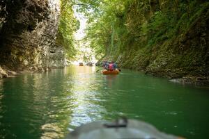 Martvili, Georgia September 2018 People on an excursion between rocks in inflatable boats along the canyon photo