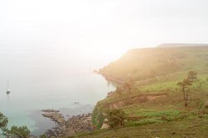 foggy day on the coast with green grass on the rocks Crozon, France 29 May 2018 photo