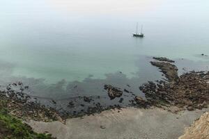 foggy day on the coast with green grass on the rocks Crozon, France 29 May 2018 photo