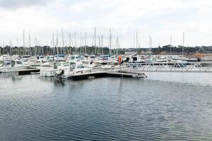 Morgat, France 29 May 2018 Panoramic outdoor view of sete marina Many small boats and yachts aligned in the port. Calm water and blue cloudy sky. photo