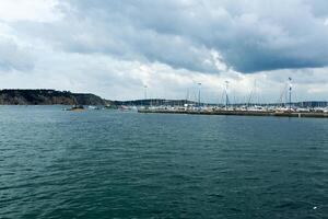 Morgat, France 29 May 2018 Panoramic outdoor view of sete marina Many small boats and yachts aligned in the port. Calm water and blue cloudy sky. photo