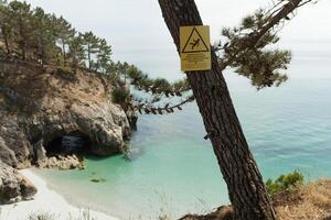 francés idioma peligro barnizar firmar en un pino árbol nera el océano. atención a el precipicio. firmar para el la seguridad de caminantes crozón, Francia 29 mayo 2018 foto