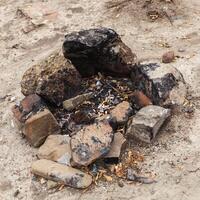 leftovers from yesterday's fire, dust and ashes, fenced with stones photo