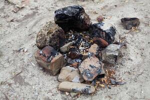 leftovers from yesterday's fire, dust and ashes, fenced with stones photo