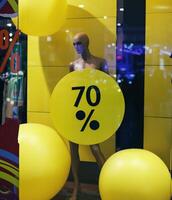 mannequin in a shop window with discount sale photo