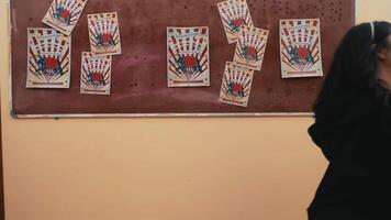 Playing cards pinned to a cork board as targets in a knife-throwing practice scene. video