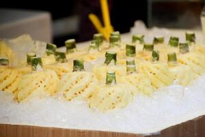 Peeled pineapples arranged on ice in the thai streets market store photo