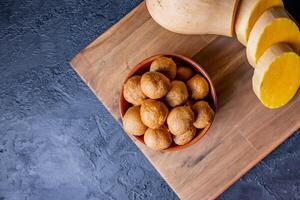 calabaza buñuelos en un mesa. acompañado por un ancó calabaza. foto