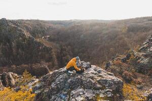 Young photographer pulls out his photographic equipment from his backpack to capture a sunset in the Divoke Sarky valley in the northern part of Prague photo