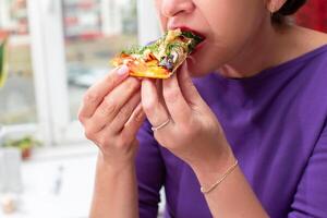 mujer manos sostener un pedazo de Pizza en su comiendo con la mano Pizza foto